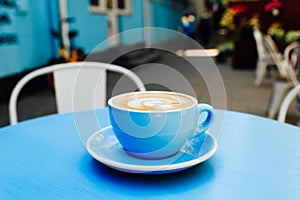 Blue cup of aromatic coffee on a blue table.