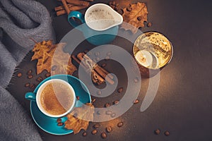 Blue cup of coffee with coffee beans and autumnal dry leaves