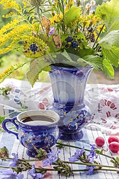 Blue cup of coffee tea chicory drink with vase, hot beverage, coffee servise on embroidered fabric background