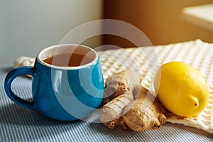 Blue cup of herbal tea with ginger and lemon