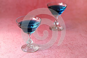 Blue curacao alcohol cocktail on a pink background. Blue curacao alcohol cocktail on a pink background. Blue alcohol or alcohol-