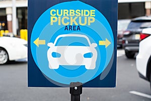Blue curbside pickup sign with a picture photo