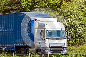 Blue curtain side lorry truck on uk motorway in fast motion