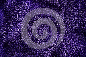 Blue dark delicate soft background of fur plush smooth fabric. Texture of purple soft fleecy blanket textile