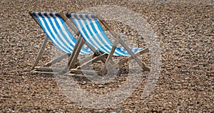 A Pair of Blue Deckchairs on a pebble beach