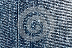 Blue denim macro texture with seam for jeans background