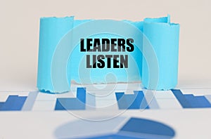 On the blue diagram and graphs there is a twisted paper plate with the inscription - Leaders Listen