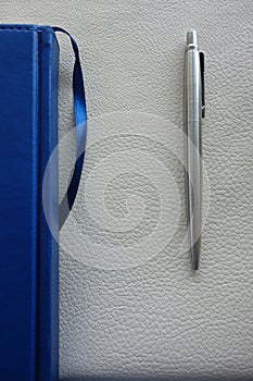 The blue diary and pen are on the table