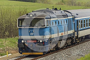 Blue diesel train with passengers coach in Jeseniky mountains
