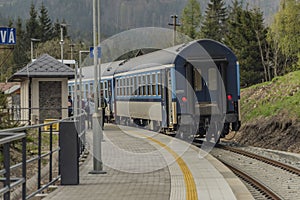 Blue diesel train with passengers coach in Jeseniky mountains