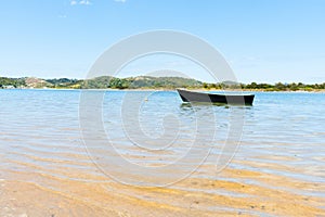 Blue dinghy afloat on peaceful calm Ngunguru estuary Northland N
