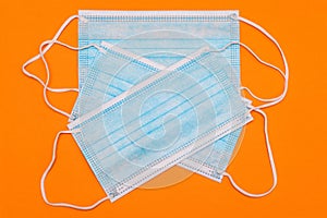 Blue disposable medical mask on a colored background. Surgical three-layer mask against viruses and diseases. Health and medicine