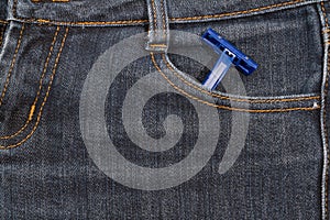 Blue disposable razor in his pocket jeans. background.