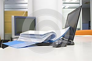 Blue Document folder with documents and Notebook on white table
