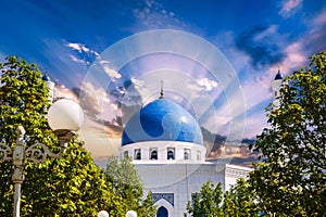 blue dome of modern white marble Islamic Masjid Minor Mosque in Tashkent in Uzbekistan on background of the sunset sky