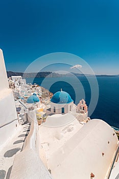 Blue dome and white Church bell tower in the village of Oia in Santorini, Greece