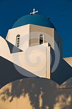 Blue dome of a white church at sunset, Oia village, Santorini island