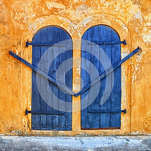 Blue door on an ancient beige wall