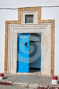 A blue door with black studs and stone ornament at doorway in Tu