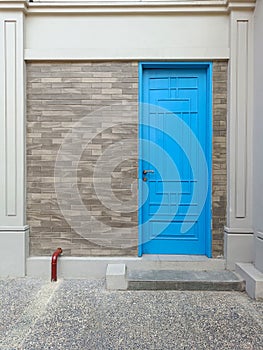 Blue Door Front View with copy space. Entrance View with Blue Door Interior with cement wall