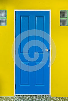 blue door is locked with yellow wall photo