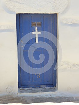 Blue door with a white cross of a  church to Amorgos in Greece.