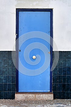 Blue door and white and blue tiled facade