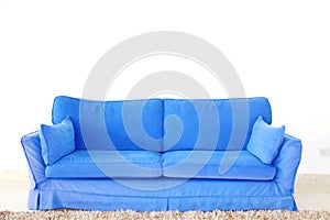 Blue double sofa on a blank wall