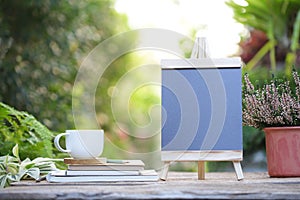 Blue Drawing board with white coffee cup and notebook with plant at outdoor