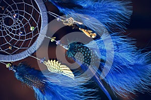 Blue dream catcher hanging on dark background