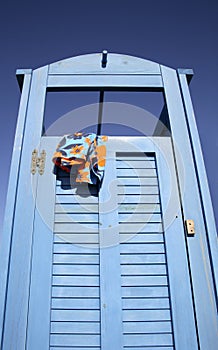 Blue dress cabin at the beach with a swimming suit hanging out