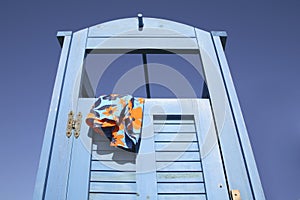 Blue dress cabin at the beach with a swimming suit hanging out