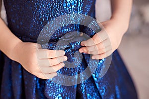 Blue dress. Great bow. Childrens hands. Horizontally