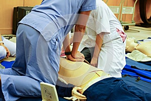 A blue dress trainee nurse performing chest compression on a man