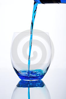 Blue drink is flowed into a glass