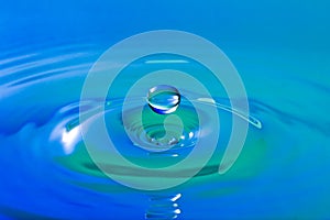Blue droplet splashing in clear clean water