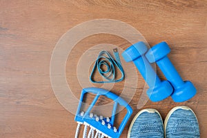 Blue dumbbells and chesty expanders on yoga mat. Fitness concept