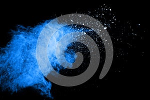 Blue dust explosion on black background. Freeze motion of color powder splash