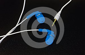 Blue earphones on black background