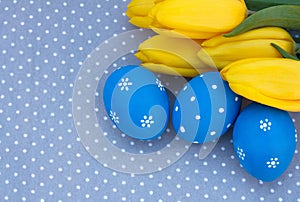 Blue easter egg with yellow tulips