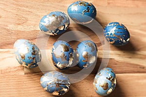 Blue easter eggs decorated gold patel on wood background photo