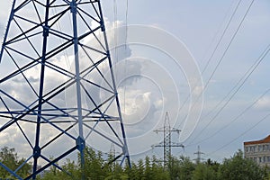 A blue electric pole transmits energy. High voltage line with wires. Electricity transmission, volt