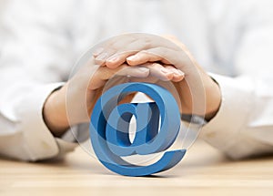 Blue email symbol protected by hands