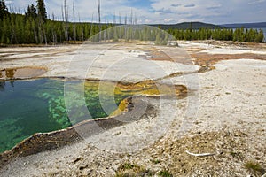 Blue and emerald water of hot spring with orange runoff.