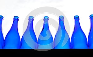 Blue empty bottles lined up on a counter