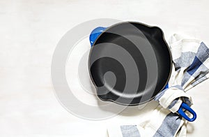 Blue empty cast iron frying pan on white background, top view