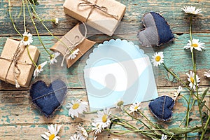 Blue envelope with chamomiles and gift boxes. Space for text.