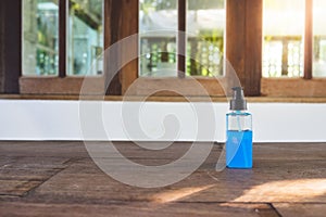 Blue Ethyl alcohol gel or hand sanitizer for coronavirus COVID-19 protection. in the plastic bottle on the wooden desk in front