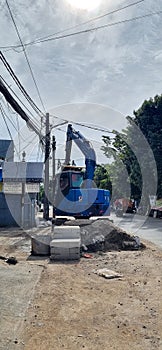 Blue excavator used to carry out street tidying projects.