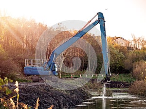 Blue excavator working on a river deepening